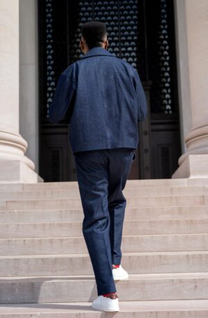 The Tessletic Marshal Set reimagines denim through the language of tailored authority. Cut in rich indigo cotton denim with clean architectural lines, this elevated set pairs a structured double-breasted jacket with relaxed pleated trousers for a look that feels equally athletic, refined, and commanding. Designed for the modern man who moves between influence, leisure, and presence with ease.