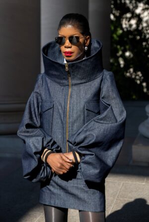 The Tessletic Max Set reimagines denim through sculptural luxury. As the debut women’s piece in the Tessletic series, it merges tailored structure with athletic ease, equally suited for elevated daywear, travel, or evening styling. Crafted in rich cotton denim, the jacket features a dramatic sculpted collar that transforms with wear. Fully zipped, it creates a bold architectural silhouette; worn open, it softens into a more relaxed elegance, offering two distinct looks in one piece. The coordinating denim mini skirt sharpens the silhouette while maintaining versatility and ease.